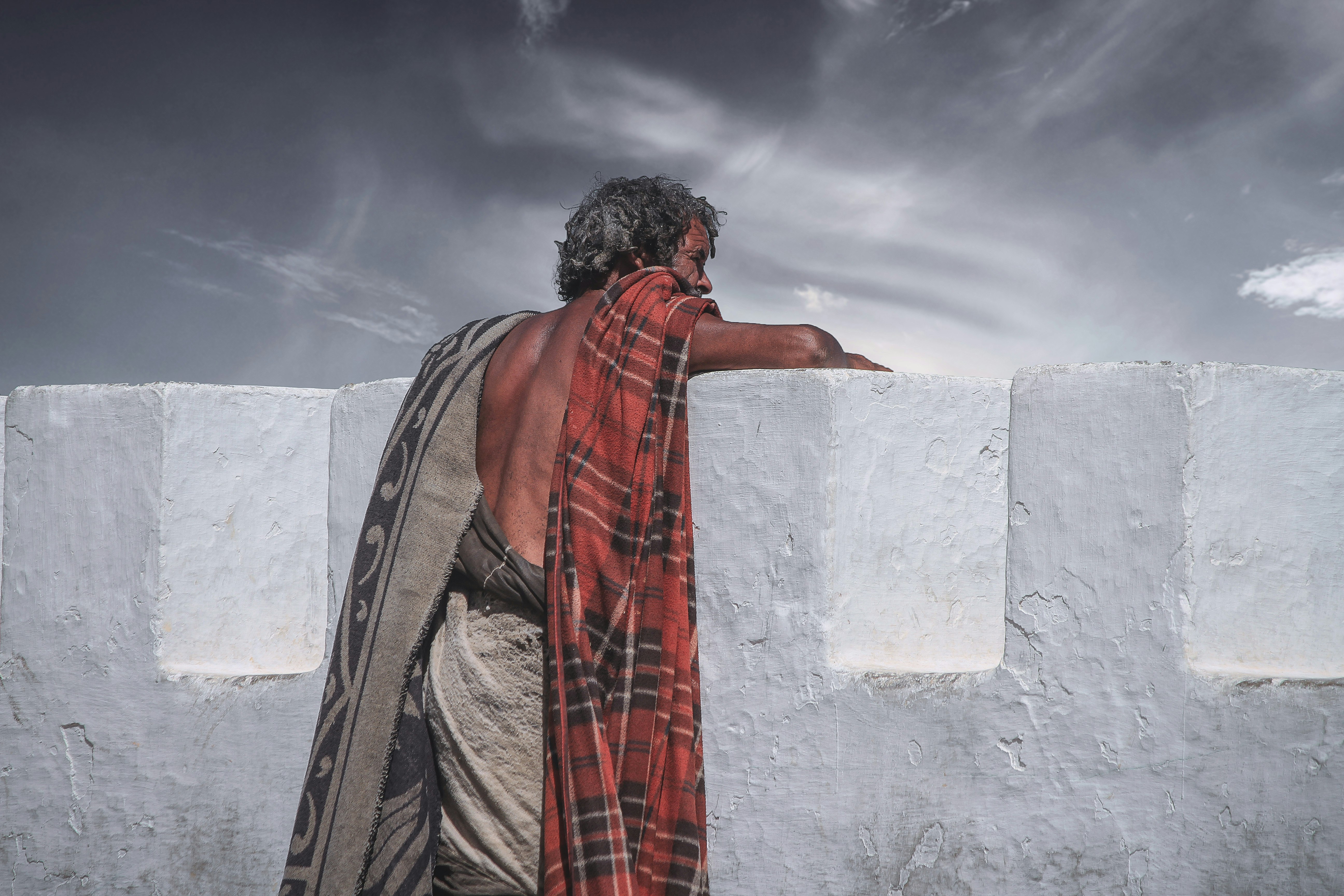 man against concrete wall looking afar